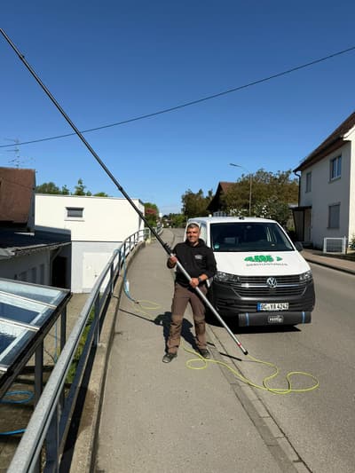 Mitarbeiter von Jakob's Dienstleistungen bei der Glasreinigung mit Teleskopstange