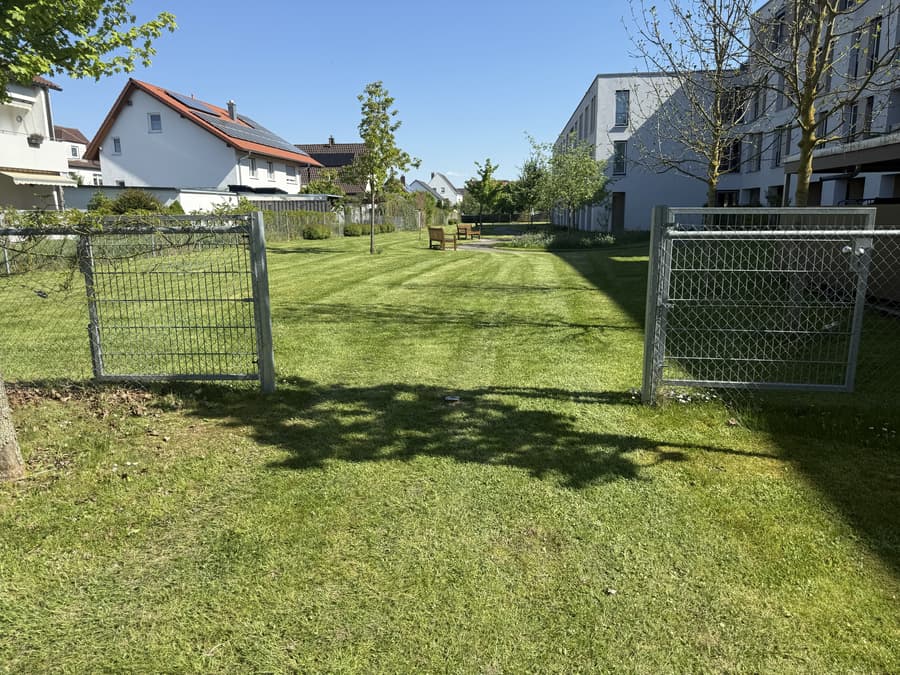 Gepflegte Außenanlage einer Wohnanlage mit frisch gemähtem Rasen