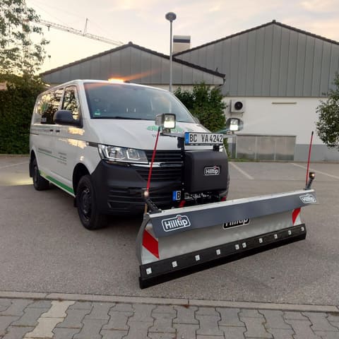 Firmentransporter mit montiertem Hilltip-Schneepflug in der Abenddämmerung